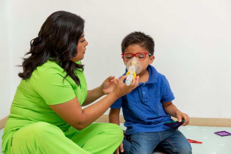 Pediatric nurse helping child using inhaler for respiratory therapy
