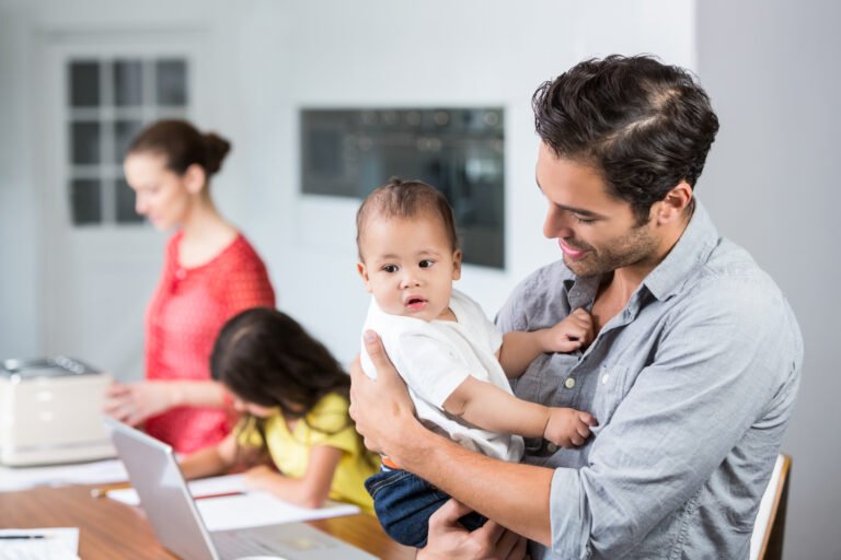 Father carrying baby with daughter and mother at home
